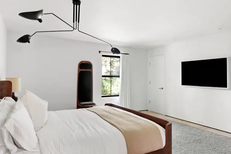 Bedroom with a walnut sleigh bed and a three-arm black ceiling lamp at the Farmstead