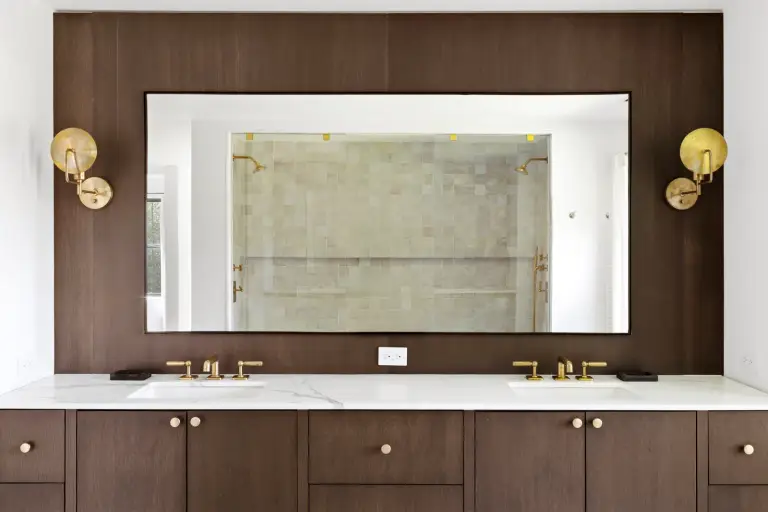 Double vanity with walnut cabinetry, marble counters and brass faucets, a zellige shower reflected in the mirror at the Farmstead