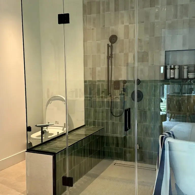 Glass-enclosed wet room with green glazed tile, rain shower head and freestanding tub at Feit Residence