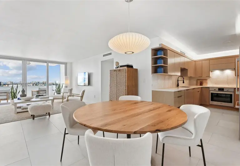 Open dining and kitchen area with oak cabinetry and a rattan-front cabinet at Silver Residence