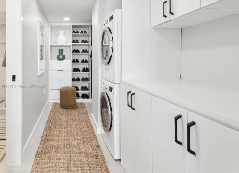 Walk-in closet with shoe shelving, drawers and a stacked washer and dryer at Silver Residence