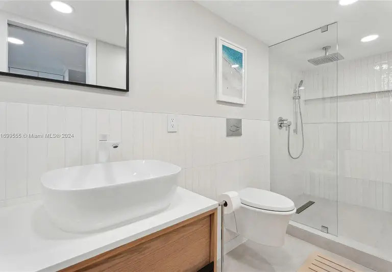 Bathroom with a vessel sink on an oak vanity and a glass-enclosed rain shower at Silver Residence