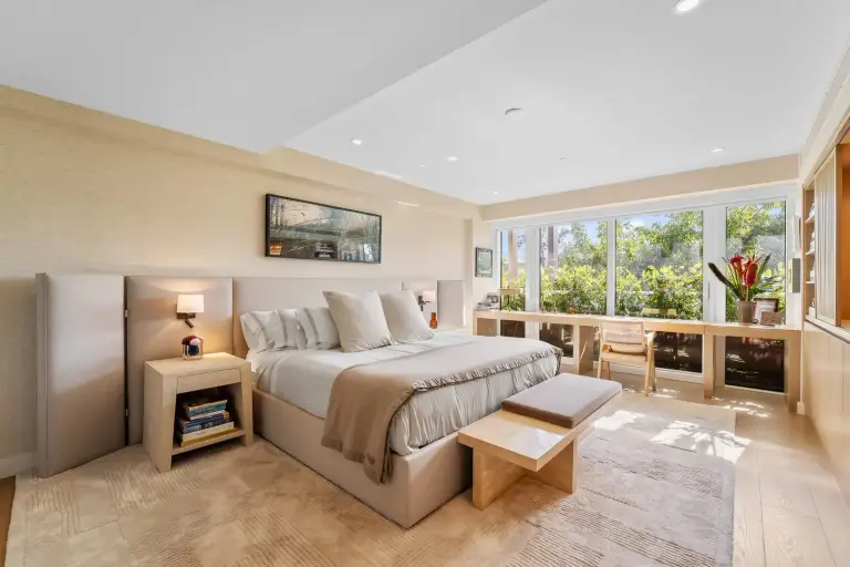 Bedroom with an upholstered bed and a console desk beneath a window at Starr DeVos Condo